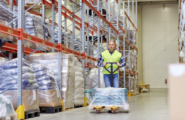 man carrying loader with goods at warehouse Stock photo © dolgachov