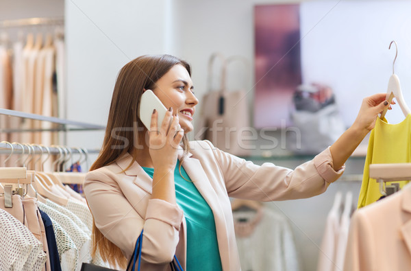 Stock photo: woman calling on smartphone at clothing store