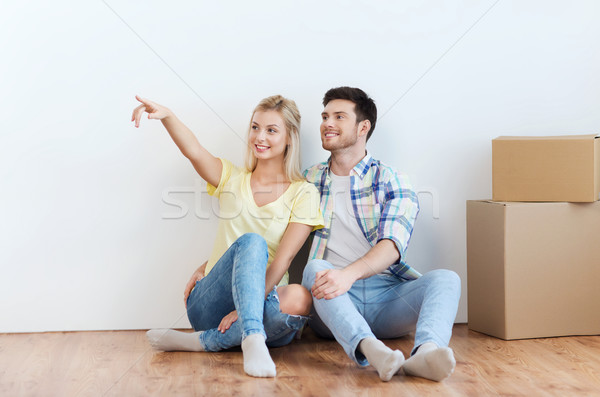 couple with boxes moving to new home and dreaming Stock photo © dolgachov