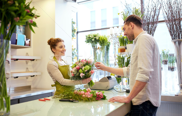 smiling florist woman and man at flower shop Stock photo © dolgachov