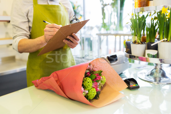 close up of man with clipboard at flower shop Stock photo © dolgachov