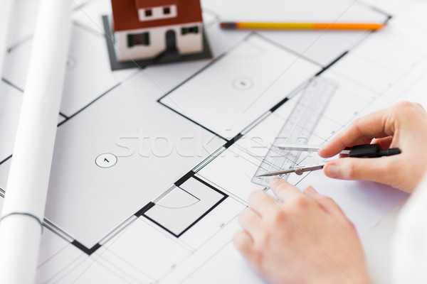 Stock photo: close up of hands with compass measuring blueprint