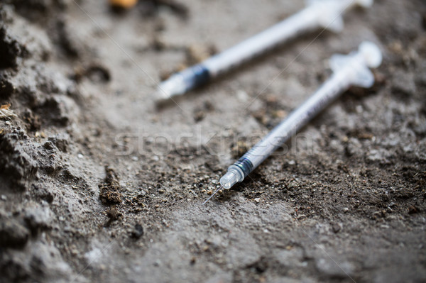 Stock photo: close up of used drug syringes on ground