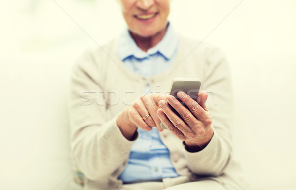 close up of senior woman with smartphone texting Stock photo © dolgachov