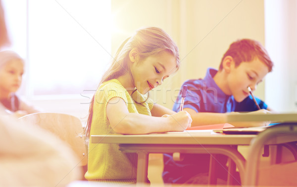 group of school kids writing test in classroom Stock photo © dolgachov