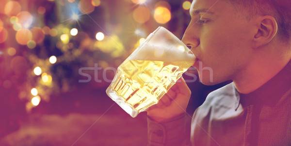 close up of young man drinking beer from glass mug Stock photo © dolgachov