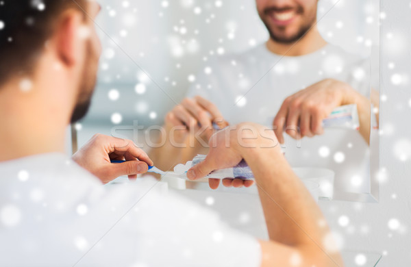 close up of man squeezing toothpaste on toothbrush Stock photo © dolgachov