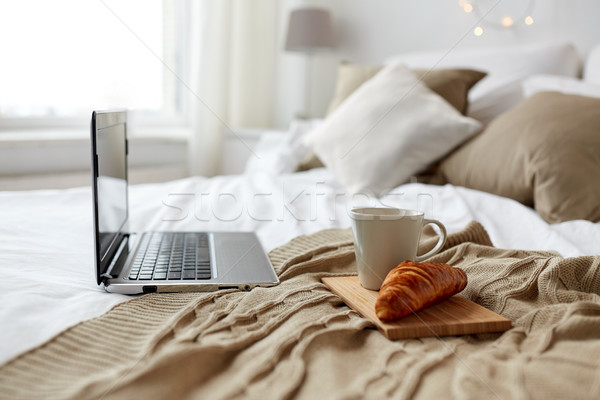 laptop, coffee and croissant on bed at cozy home Stock photo © dolgachov