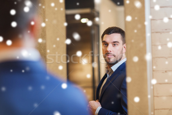 man trying jacket on at mirror in clothing store Stock photo © dolgachov