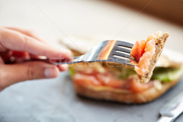 Kobieta jedzenie łososia panini kanapkę jedzenie w restauracji Zdjęcia stock © dolgachov