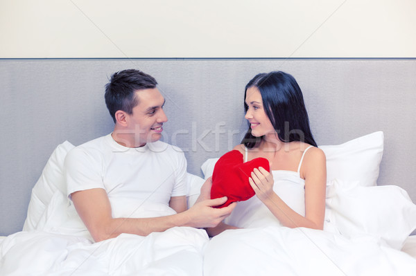 Gülen çift yatak kırmızı kalp şekli yastık Stok fotoğraf © dolgachov