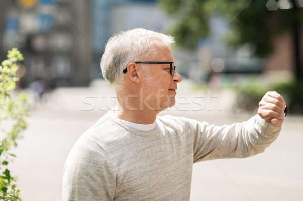 senior man checking time on his wristwatch Stock photo © dolgachov