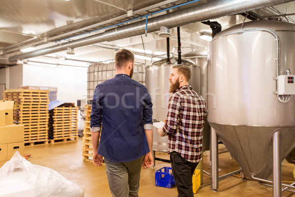 men with clipboard at craft brewery or beer plant Stock photo © dolgachov