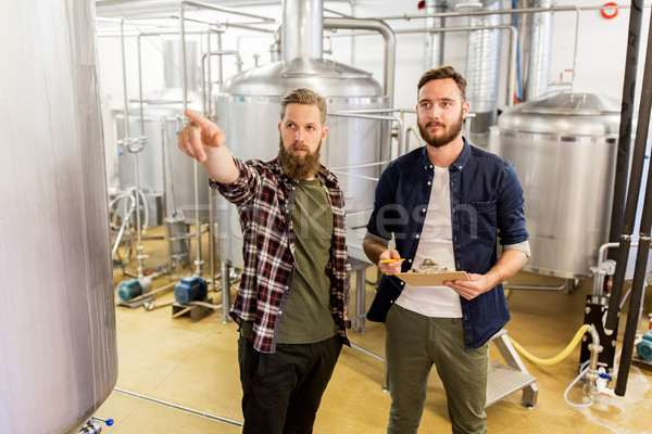 Stock photo: men with clipboard at craft brewery or beer plant