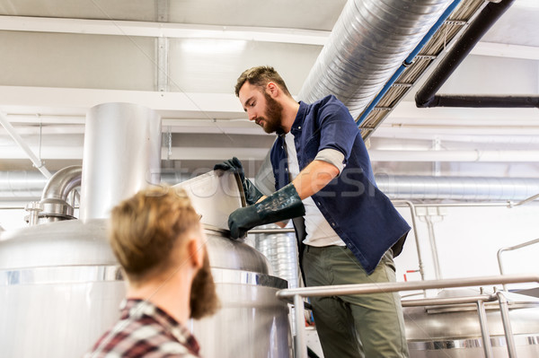 men working at craft brewery or beer plant Stock photo © dolgachov