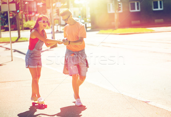 teenage couple riding skateboards on city street Stock photo © dolgachov