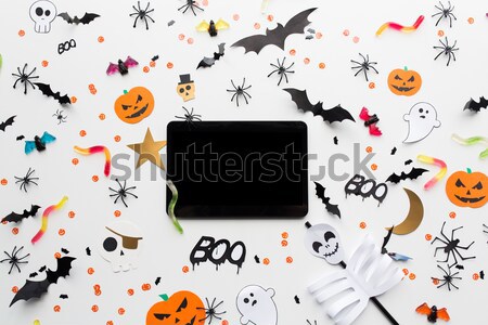 tablet pc, halloween party decorations and candies Stock photo © dolgachov