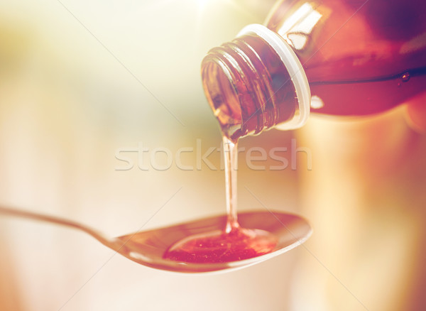 medication or antipyretic syrup and spoon Stock photo © dolgachov