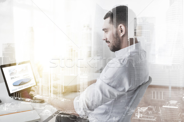 businessman with charts on laptop screen at office Stock photo © dolgachov