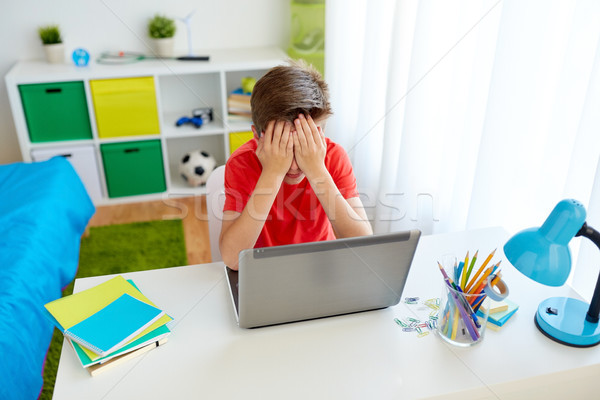 upset student boy with laptop computer at home Stock photo © dolgachov