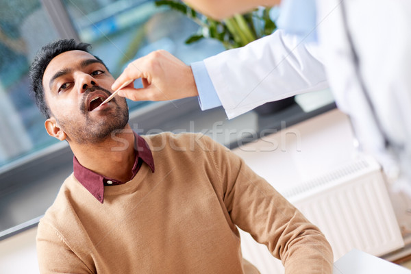 doctor examining patient throat at clinic Stock photo © dolgachov
