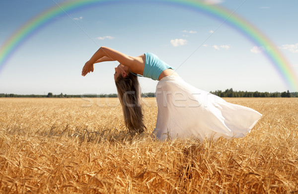 stretching woman in the meadow with rainbow Stock photo © dolgachov