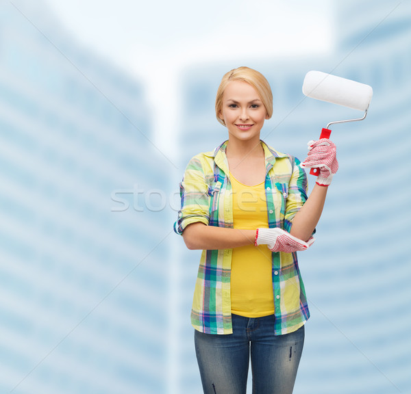 smiling woman in gloves with paint roller Stock photo © dolgachov