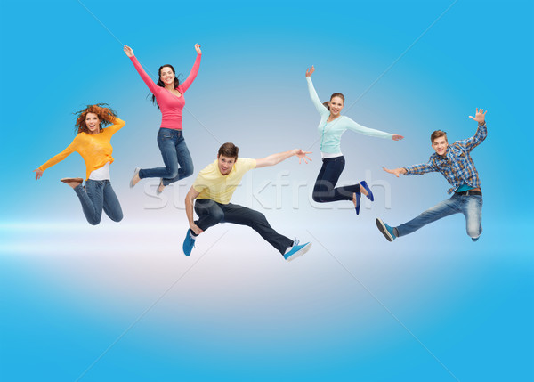 Grupo sorridente adolescentes saltando ar felicidade Foto stock © dolgachov