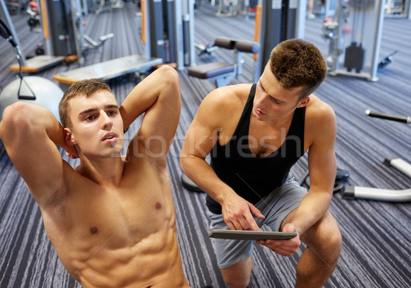 men flexing abdominal muscles in gym Stock photo © dolgachov