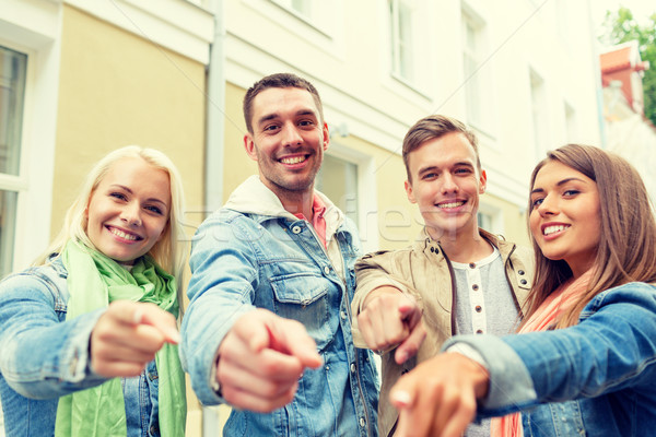 group of smiling friends in city pointing finger Stock photo © dolgachov