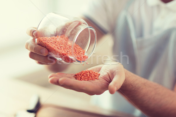 close up of male emptying jar with red lentils Stock photo © dolgachov