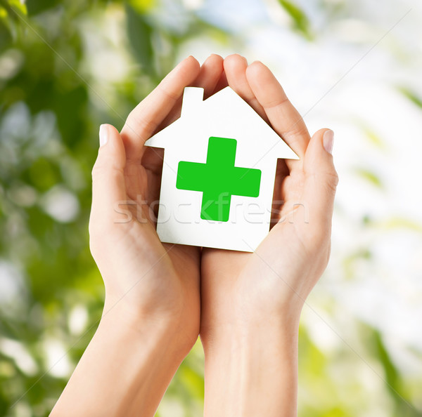 Stock photo: hands holding paper house with green cross