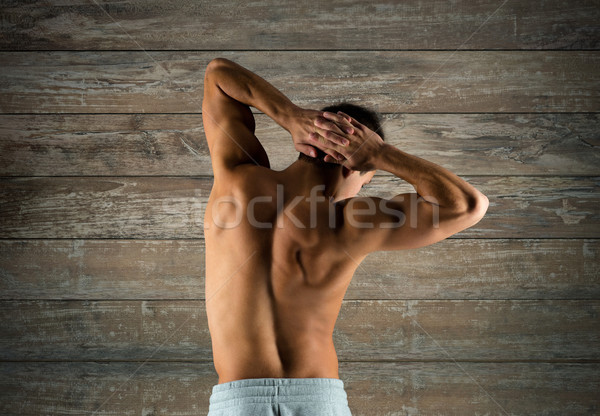 young man or bodybuilder showing muscles Stock photo © dolgachov