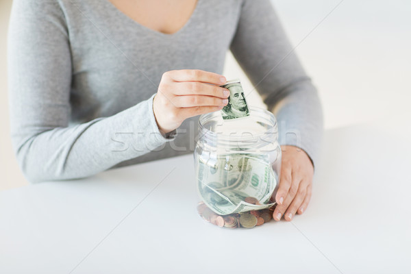 close up of woman hands and dollar money in jar Stock photo © dolgachov