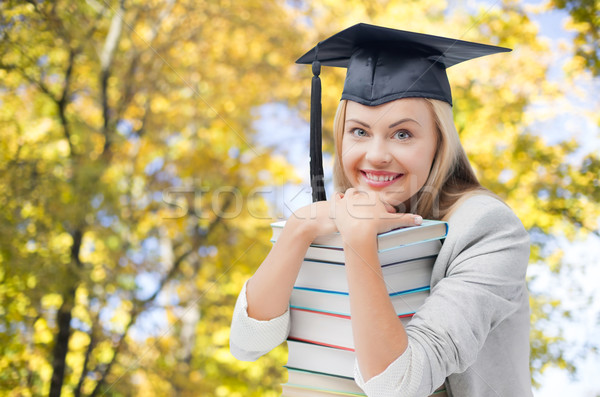 happy student girl in bachelor cap with books Stock photo © dolgachov