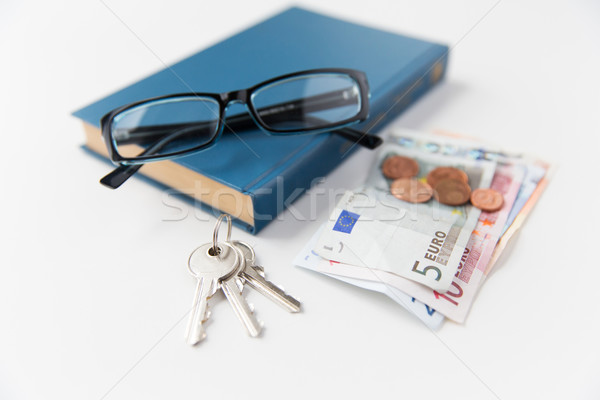 close up of book, money, glasses and keys on table Stock photo © dolgachov