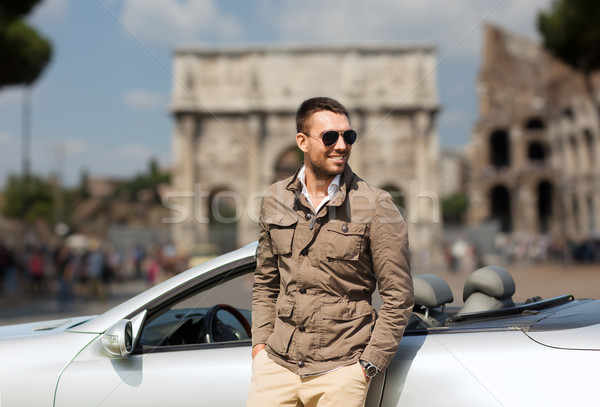 happy man driving cabriolet car over city of rome Stock photo © dolgachov