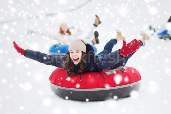 group of happy friends sliding down on snow tubes Stock photo © dolgachov