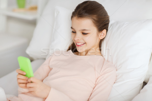 Mädchen glücklich Bett Smartphone home Menschen Kinder Stock foto © dolgachov