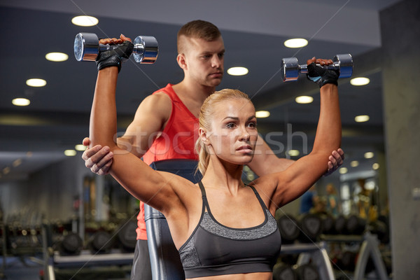 man and woman with dumbbells in gym Stock photo © dolgachov