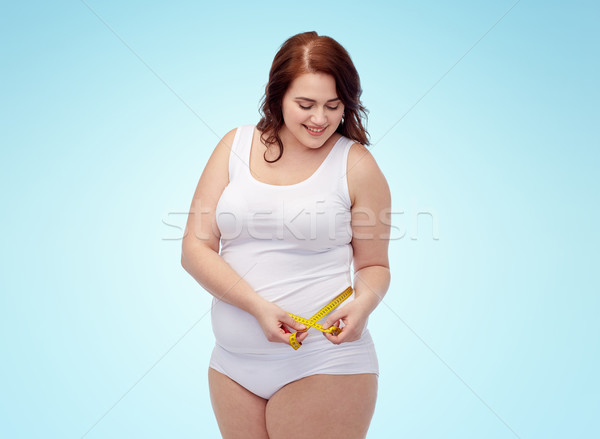 happy young plus size woman with measuring tape Stock photo © dolgachov