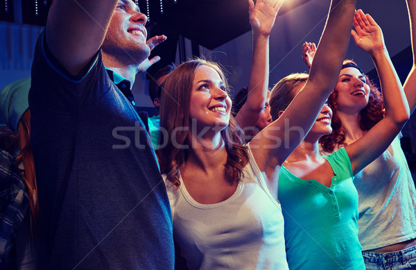 Stock photo: smiling friends at concert in club