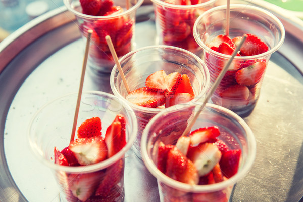 strawberry in plastic cups at street market Stock photo © dolgachov