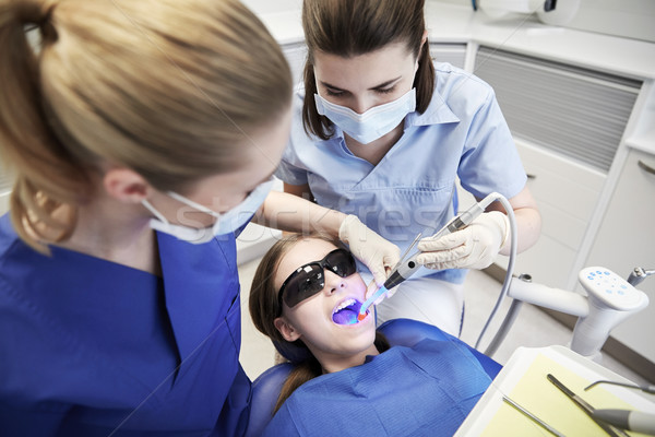 female dentists treating patient girl teeth Stock photo © dolgachov