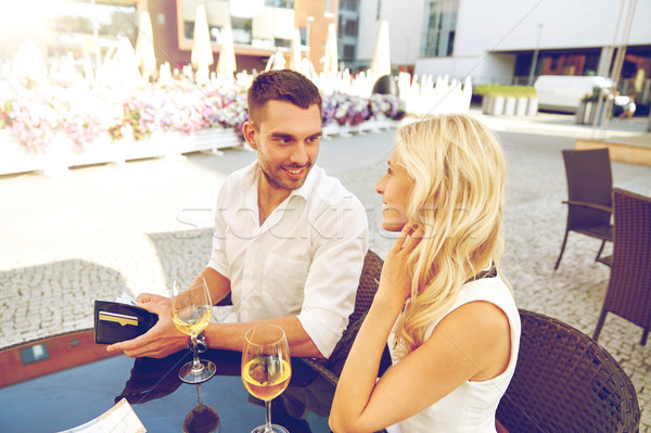 happy couple with wallet paying bill at restaurant Stock photo © dolgachov