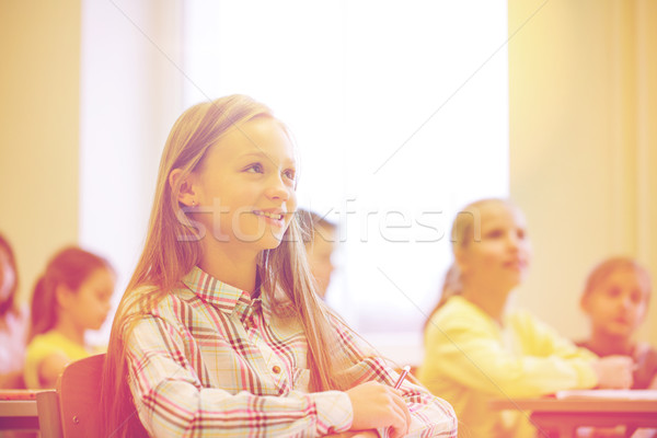 group of school kids with notebooks in classroom Stock photo © dolgachov