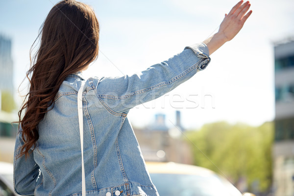 Stock photo: young woman or girl catching taxi on city street