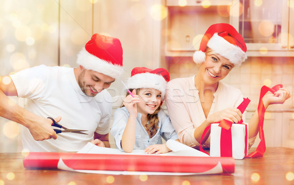 smiling family in santa helper hats with gift box Stock photo © dolgachov