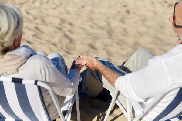 senior couple sitting on chairs at summer beach Stock photo © dolgachov