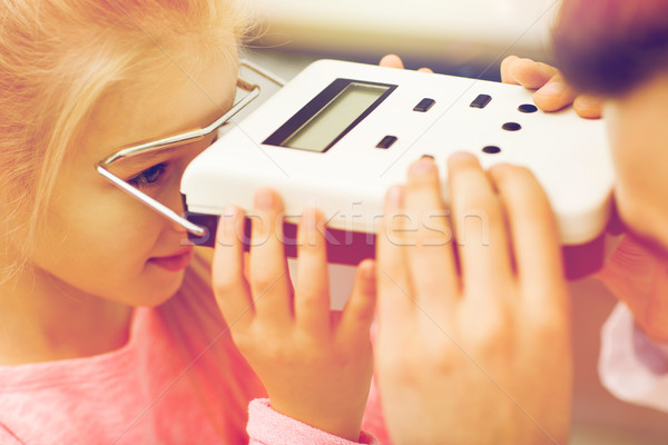 optician with pupillometer and girl at eye clinic Stock photo © dolgachov
